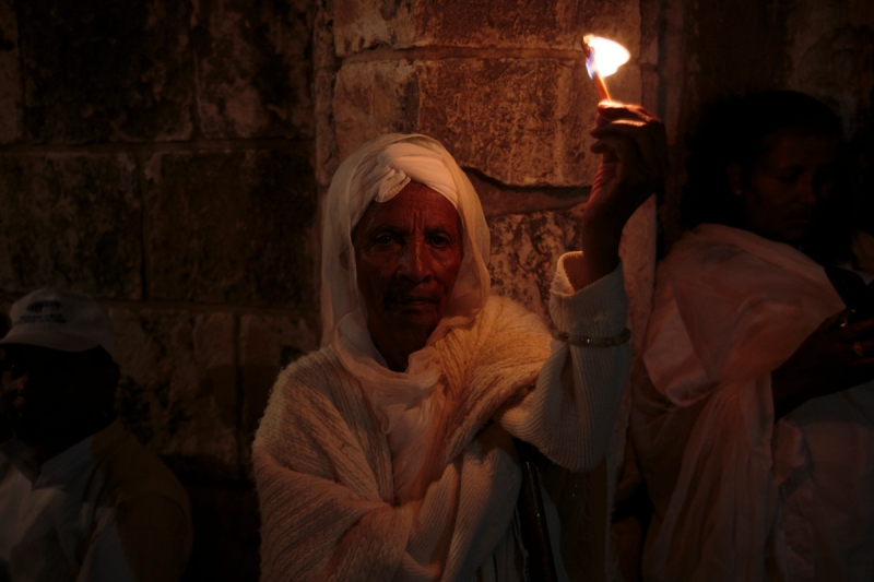 A woman holds a candle during the Ethiopian Easter celebration in the Old City.  