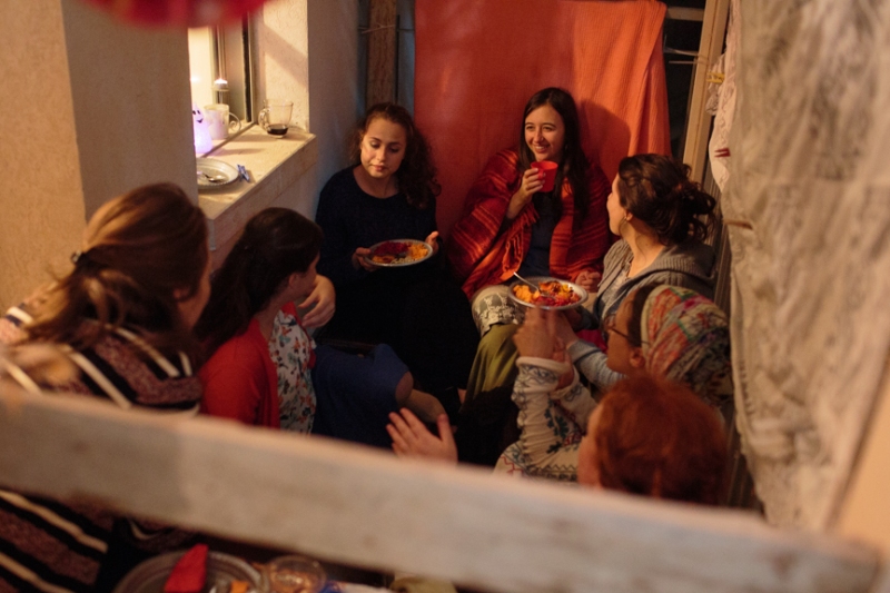 A group of girls sit and eat in a sukkah during the holiday of Sukkot in Jerusalem.  